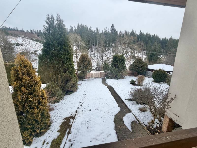 Prenájom exkluzívneho domu v Čadci- Čadečke - Zasnežená záhrada rodinného domu v Čadci na ulici Čadečka s ihličnanmi a trávnikom.