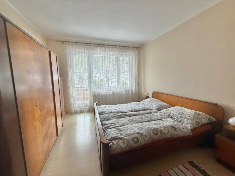 Prenájom exkluzívneho domu v Čadci- Čadečke - Spálňa s manželskou posteľou, skriňou a podlahou s dreveným dekorom v rodinnom dome.