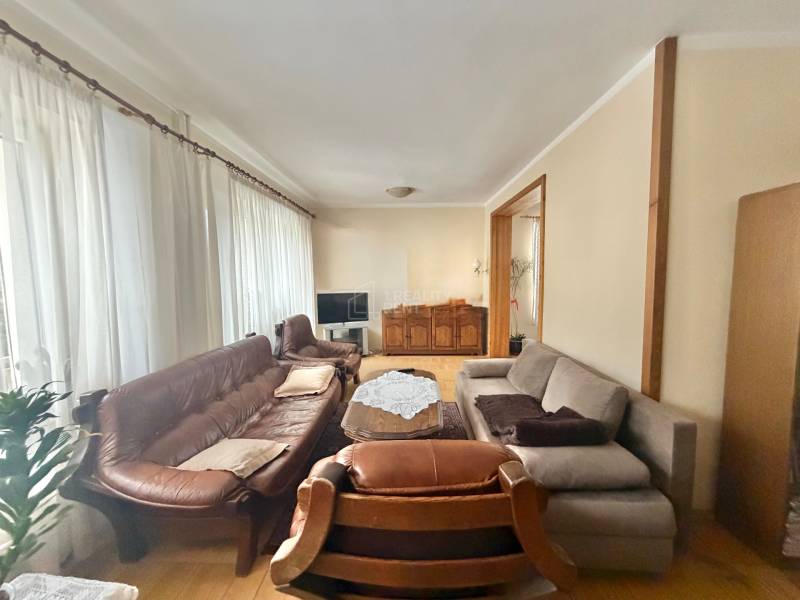 Prenájom exkluzívneho domu v Čadci- Čadečke - Obývačka v rodinnom dome s podlahou s dreveným dekorom, sedačkou a záclonami.