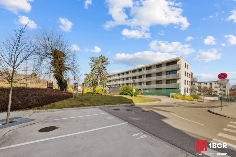 PROJEKT POD VINICOU | 4-IZB. BYT, UZAVRETÝ AREÁL, HOLOBYT, NOVOSTAVBA - Bytový dom na Skalickej ceste v Bratislave - Novom Meste. V popredí sú parkovacie miesta.