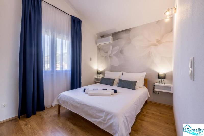 Kaštela(HR)-moderná vila s krásnym výhľadom - Spálňa vo Vile s veľkými kvetmi na stene a podlahou s dreveným dekorom.