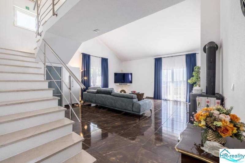 Kaštela(HR)-moderná vila s krásnym výhľadom - Obývacia izba vily s lesklou podlahou a modrými závesmi.