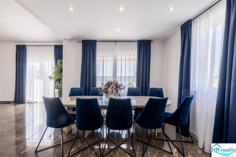 Kaštela(HR)-moderná vila s krásnym výhľadom - Jedáleň vo Vile s tmavými závesmi, podlahou s dreveným dekorom a modrými stoličkami.