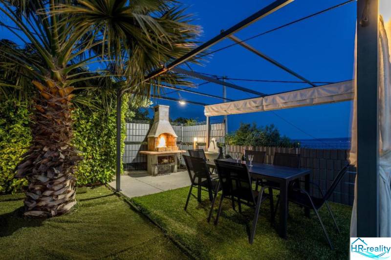 Kaštela(HR)-moderná vila s krásnym výhľadom - Palmová záhrada vily v Kaštela s pergolou, krbom a stolom.