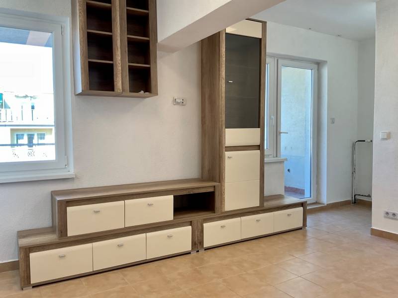 I Predaj Investičného 1-izbového bytu s veľkorysou loggiou  - Obývací priestor v 1-izbovom byte s nábytkom a keramickou podlahou.