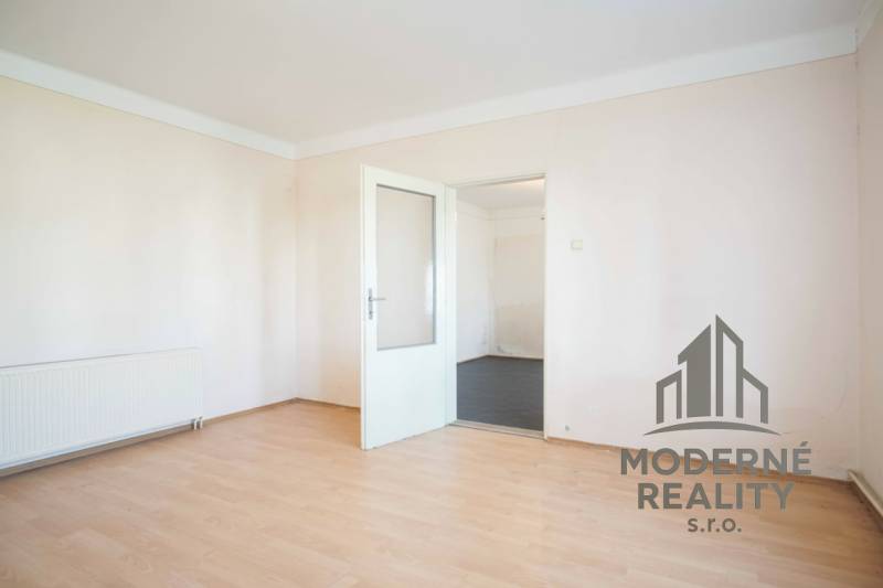 Rodinný dom v centre s garážou, Dvory nad Žitavou, 798m2 - Izba v rodinnom dome s bielymi stenami a podlahou s dreveným dekorom.