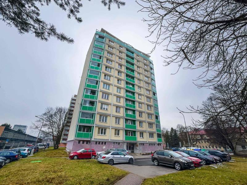 2 IZBOVÝ BYT S LODŽIOU - CENTRUM NA DOSAH - TICHÁ LOKALITA - Výškový bytový dom na Triedy Snp v Banskej Bystrici s parkoviskom v popredí.