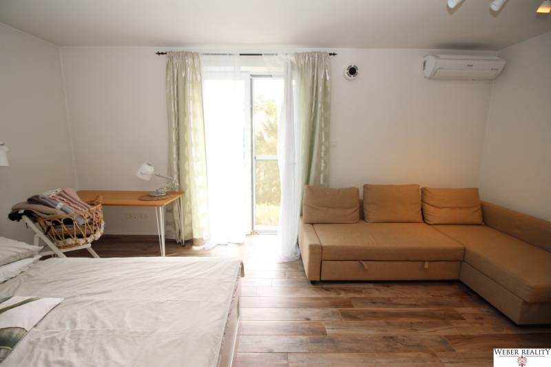 1-izb. kompletne zrekonštr.byt na Hradnom kopci (Lichardova ul.)  - 1-izbový byt s gaučom, posteľou, písacím stolom a podlahou s dreveným dekorom.