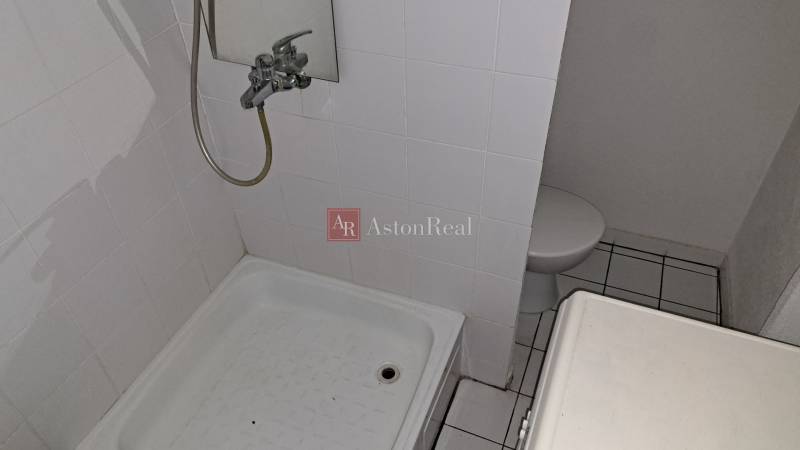 PREDAJ: 1 izbový byt - 37m2, s loggiou, Ružomberok - Za dráhou - Kúpeľňa v 1-izbovom byte s bielym obkladom a sprchovacím kútom.