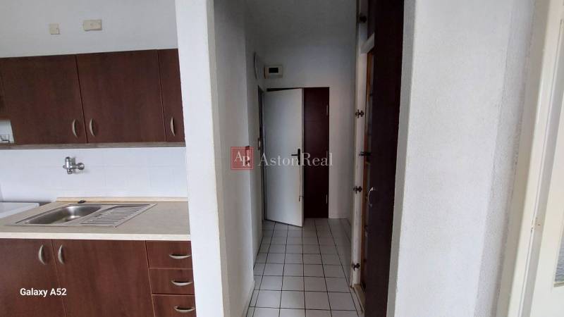 PREDAJ: 1 izbový byt - 37m2, s loggiou, Ružomberok - Za dráhou - Kuchyňa s tmavými skrinkami a bielymi obkladačkami v 1-izbovom byte.