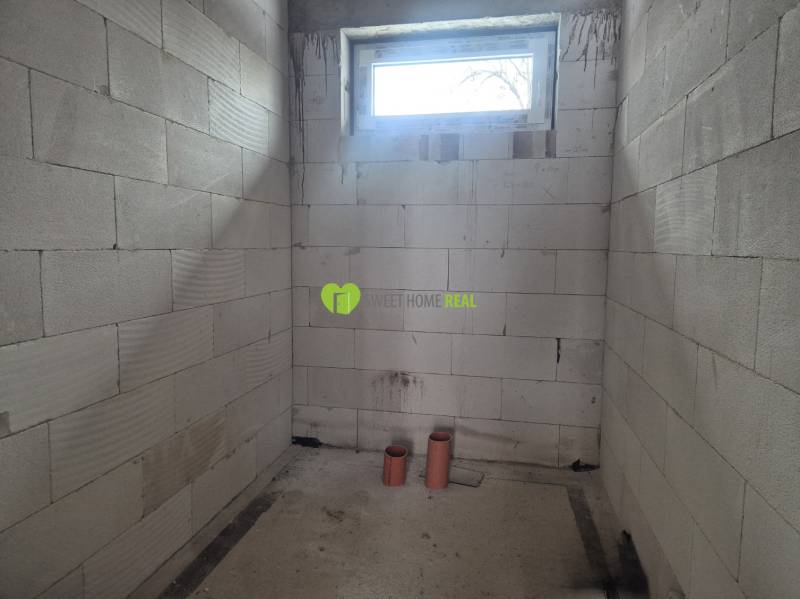 Novostavba 4i RD - Bungalov v obci Bidovce, KE-okolie - Neomietnuté steny, malé okno a PVC rúrky v rodinnom dome.