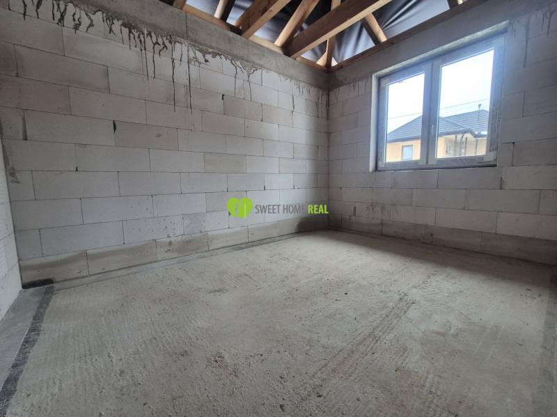 Novostavba 4i RD - Bungalov v obci Bidovce, KE-okolie - Betónová podlaha, nepomaľované tehly a drevené trámy v interiéri rodinného domu.