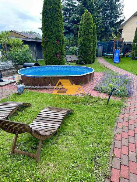 Predám peknú chatu na celoročné bývanie v Nových zámkoch - Záhrada chaty v Nových Zámkoch s bazénom, lehátkami a detským ihriskom.