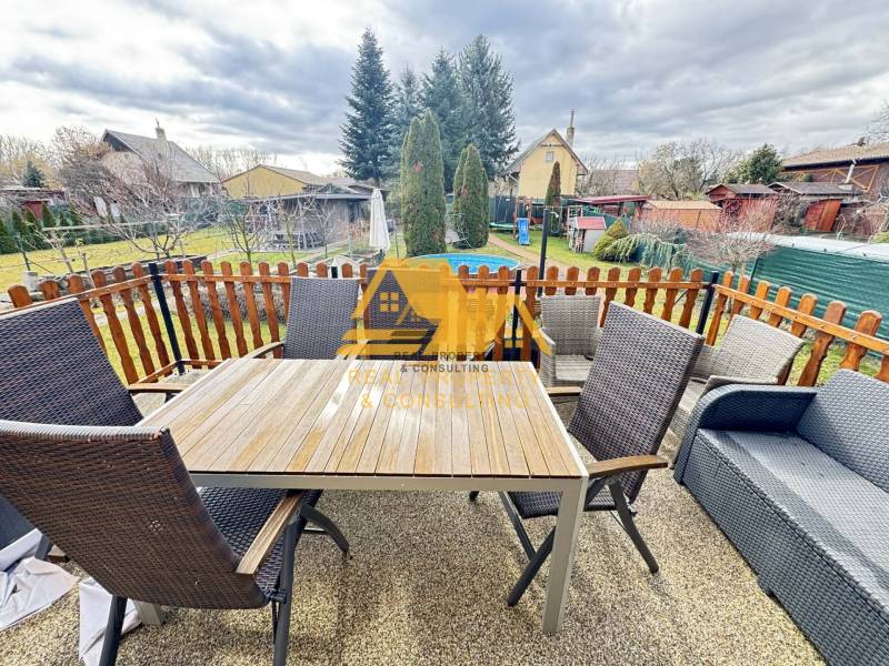 Predám peknú chatu na celoročné bývanie v Nových zámkoch - Na terase chaty v Nových Zámkoch sa nachádza stôl s kreslami a pohovkou.