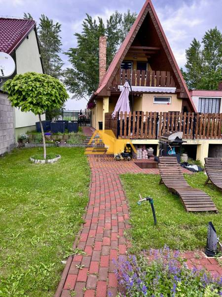 Predám peknú chatu na celoročné bývanie v Nových zámkoch - Chata v obci Nové Zámky s červenou strechou, terasou a záhradou na oddych.