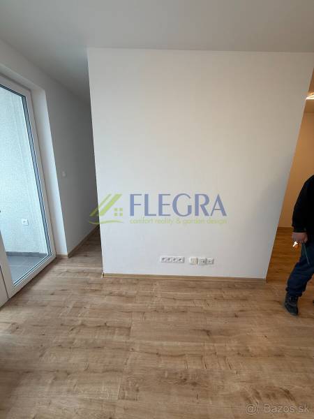 Na predaj 1,5-izbový byt v novostavbe GREENSIDE Trebišov - Interiér v 1-izbovom byte s podlahou s dreveným dekorom a balkónom.