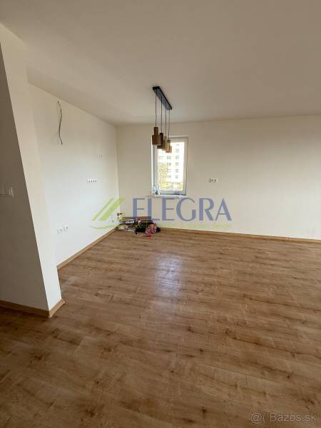 Na predaj 2 izbový byt GEENSIDE Trebišov - Izba 2-izbového bytu s podlahou s dreveným dekorom a závesnými svietidlami.