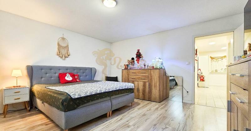 Rodinný dom v obci Bernolákovo, po kompletnej rekonštrukcii - Spálňa v rodinnom dome s podlahou s dreveným dekorom a vianočnými dekoráciami.