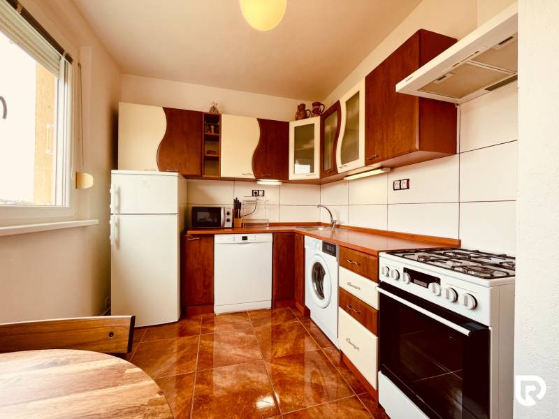 EXKLUZÍVNE! | Krásny 2-izbový byt | 52m² | Považanova - Kuchyňa v 2-izbovom byte s podlahou s dreveným dekorom, obsahujúca spotrebiče a nábytok.