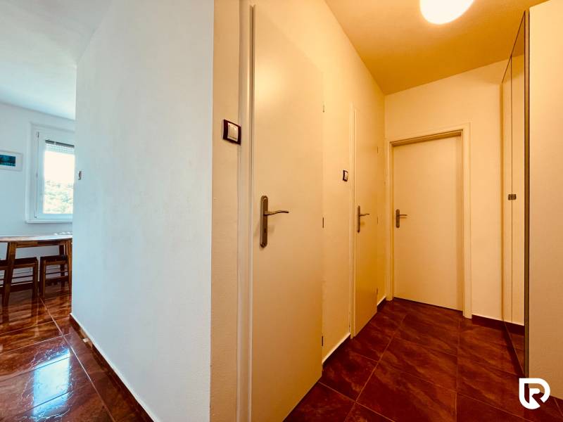 EXKLUZÍVNE! | Krásny 2-izbový byt | 52m² | Považanova - Chodba v 2-izbovom byte s hnedými lesklými dlažbami a bielymi stenami.