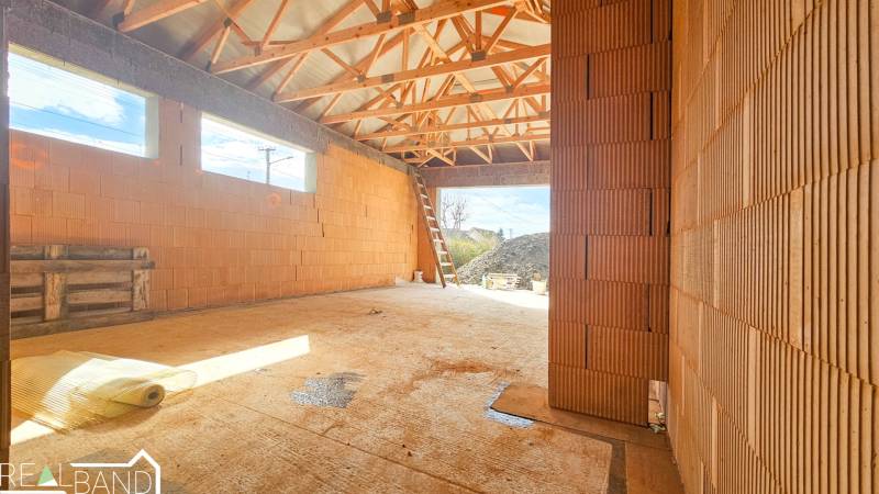 PRIESTRANNÁ 4-IZBOVÁ NOVOSTAVBA 167.38m²- BUNGALOV NA POZEMKU AŽ 702m² - Stavba rodinného domu v Pavliciach s viditeľnou konštrukciou strechy.