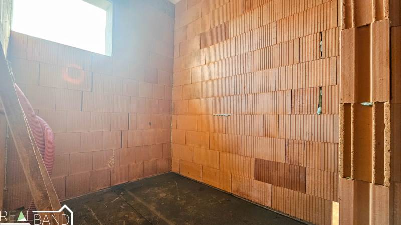 PRIESTRANNÁ 4-IZBOVÁ NOVOSTAVBA 167.38m²- BUNGALOV NA POZEMKU AŽ 702m² - Stena z tehál a podlaha s dreveným dekorom v rodinnom dome.