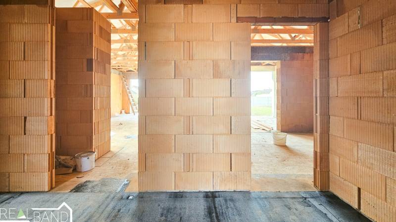 PRIESTRANNÁ 4-IZBOVÁ NOVOSTAVBA 167.38m²- BUNGALOV NA POZEMKU AŽ 702m² - Interiér rozostavaného rodinného domu s neomietnutými tehlovými stenami a výhľadom do exteriéru.