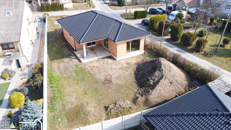 PRIESTRANNÁ 4-IZBOVÁ NOVOSTAVBA 167.38m²- BUNGALOV NA POZEMKU AŽ 702m² - Rodinný dom v Pavliciach obklopený ulicou a záhradou s hlinou.