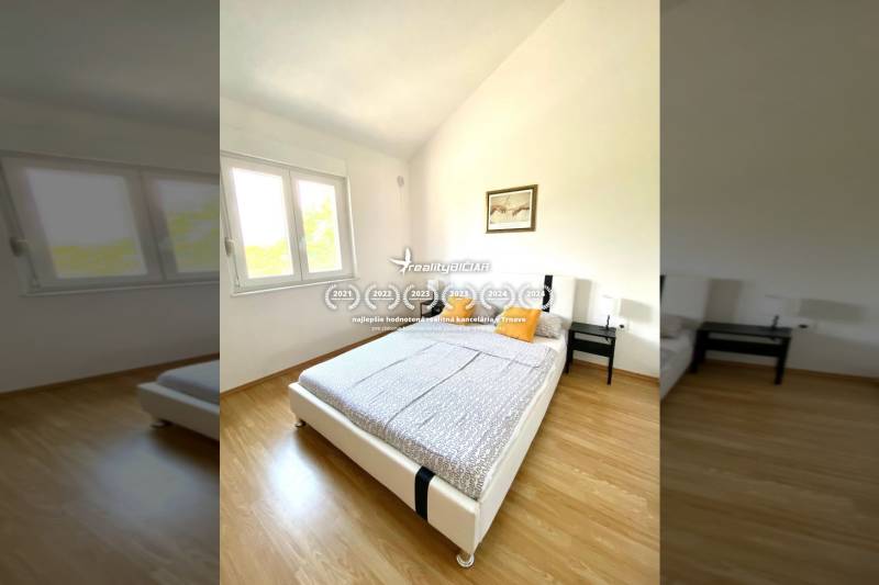 NIN-GRBLJANSKE VIKENDICE - dom s dvoma bytmi - Spálňa v rodinnom dome s podlahou s dreveným dekorom, posteľou a oknom.