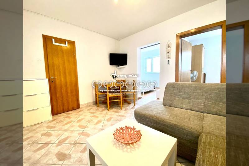 NIN-GRBLJANSKE VIKENDICE - dom s dvoma bytmi - Obývacia izba v rodinnom dome s pohovkou, stolíkom a televíziou na stene.