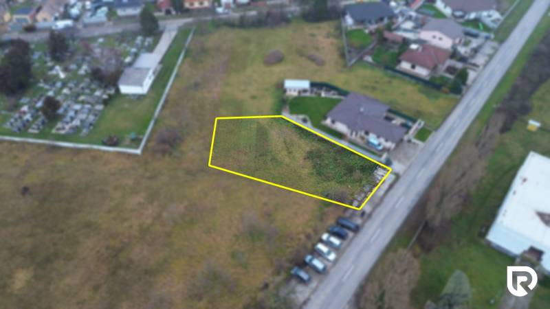 Stavebný pozemok 946m2 pre Rodinný dom | Mierovo - Pozemok na bývanie v Mierove na ulici Mierová, pri ceste, vedľa auta a domu.