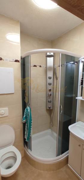 1-izb. byt, Krížná ul., Staré Mesto s veľkou lodžiou - Kúpeľňa v 1-izbovom byte s rohovou sprchou, umývadlom a WC.