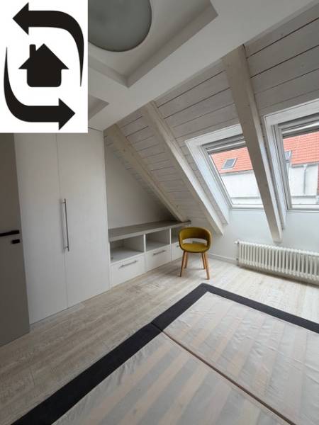 4 Izbový byt na Medenej ulici na prenájom - Podkrovná izba s podlahou s dreveným dekorom, vstavanou skriňou a žltou stoličkou.