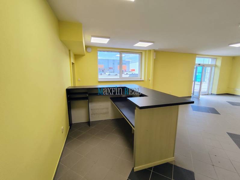 Obchodný priestor v Nitre s parkovaním - Svetlé obchodné priestory s pultom a dlažbou na podlahe.