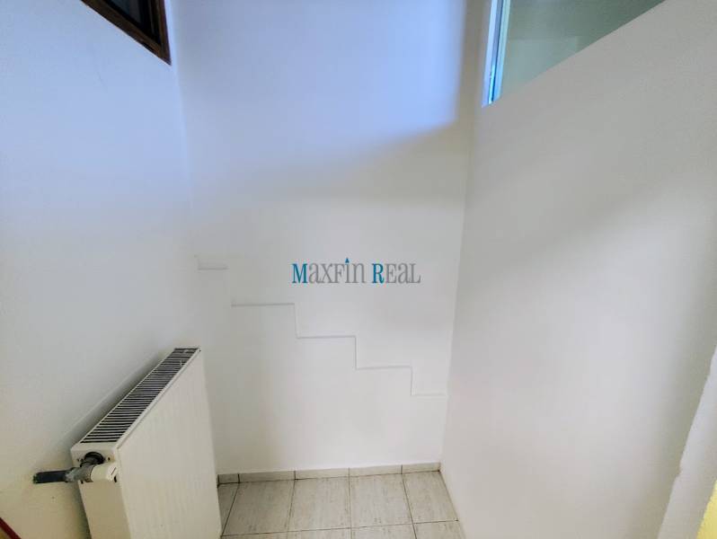 Obchodný priestor v Nitre s parkovaním - Obchodné priestory s radiátorom a bielymi stenami, podlaha s bielym obkladom.