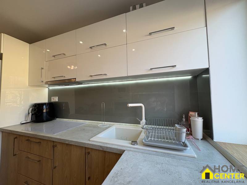 NA PREDAJ vkusne zrekonštruovaný  2 izbový byt, Komárno - Kuchyňa v 2-izbovom byte so svetlými skrinkami a podsvietením nad pracovnou doskou.