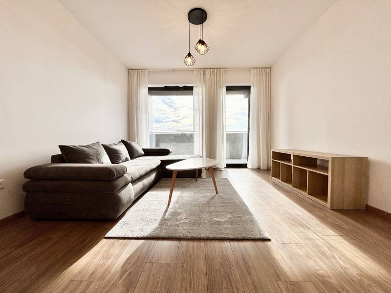 I PRENÁJOM - Nový moderný 2-izb. byt, TEHELNÉ POLE, Bajkalská - Obývačka s pohodlnou pohovkou a dreveným nábytkom na ulici Bajkalská, 2-izbový byt.