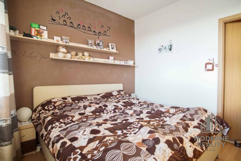 3-izbový byt s loggiou na ul. S.H. Vajanského, Nové Zámky – 74,69m2 - Spálňa v 3-izbovom byte s dekorovanou stenou a výraznými posteľnými obliečkami.