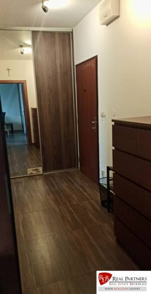 Prenájom 2-izbový byt na začiatku Petržalky - Chodba v 2-izbovom byte s podlahou s dreveným dekorom, vstavanou skriňou a zrkadlovým prvkom.