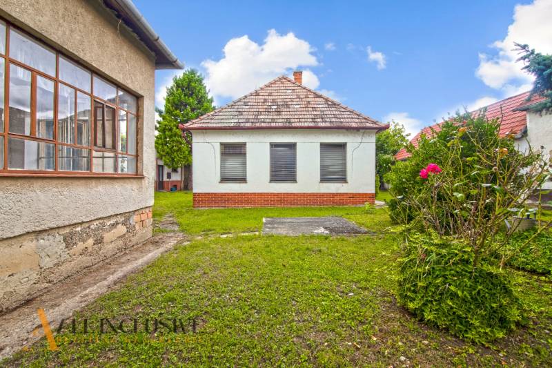 NA PREDAJ 2 ROD. DOMY NA 12-ÁROVOM POZEMKU, MALÁ MAČA - Záhrada rodinného domu v Malej Mači pri Galante so zeleným trávnikom a kvetmi.