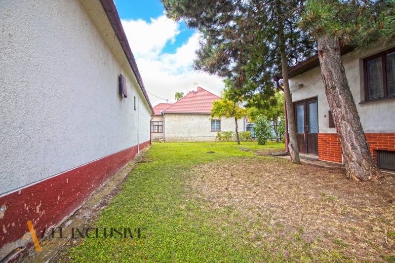 NA PREDAJ 2 ROD. DOMY NA 12-ÁROVOM POZEMKU, MALÁ MAČA - Rodinný dom na ulici Malá Mača v Galante, obklopený zeleňou a stromami.