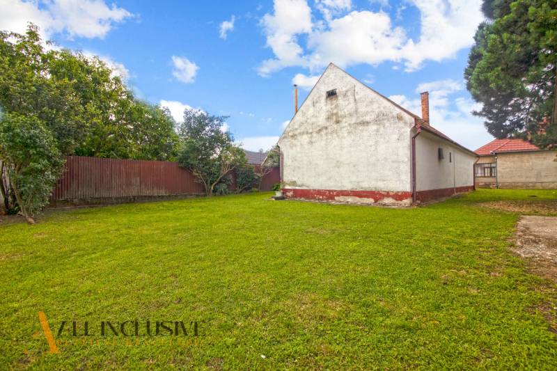 NA PREDAJ 2 ROD. DOMY NA 12-ÁROVOM POZEMKU, MALÁ MAČA - Rodinný dom na ulici Malá Mača v Galante s priestranným trávnikom a stromami.