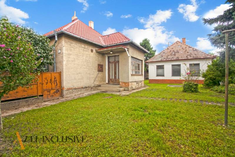 NA PREDAJ 2 ROD. DOMY NA 12-ÁROVOM POZEMKU, MALÁ MAČA - Rodinný dom na ulici Malá Mača v Galante s červenou strechou a veľkým pozemkom.