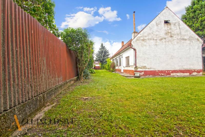 NA PREDAJ 2 ROD. DOMY NA 12-ÁROVOM POZEMKU, MALÁ MAČA - Rodinný dom na ulici Malá Mača v Galante so záhradou a plotom.