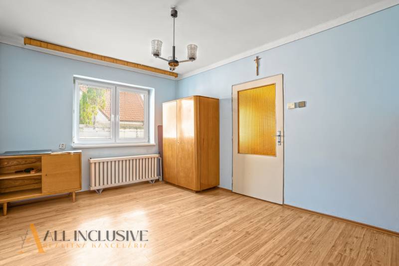 NA PREDAJ 3-IZBOVÝ RODINNÝ DOM, PUSTÉ ÚĽANY - Izba v rodinnom dome s podlahou s dreveným dekorom a nábytkom svetlej farby.