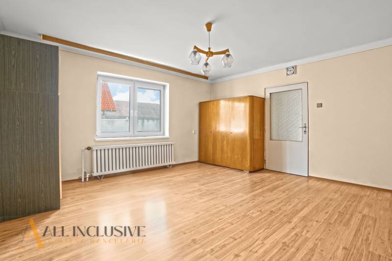 NA PREDAJ 3-IZBOVÝ RODINNÝ DOM, PUSTÉ ÚĽANY - Interiér rodinného domu s podlahou s dreveným dekorom, skriňou a lustrom.