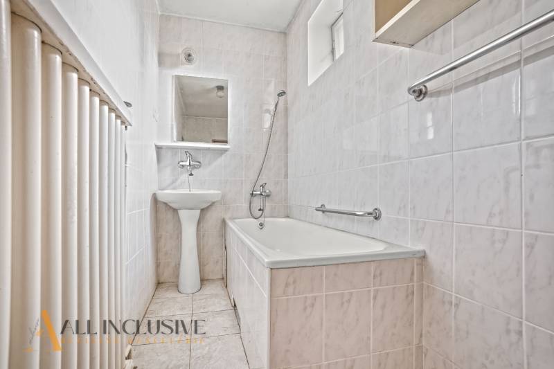 NA PREDAJ 3-IZBOVÝ RODINNÝ DOM, PUSTÉ ÚĽANY - Kúpeľňa v rodinnom dome s vaňou, umývadlom a radiátorom.