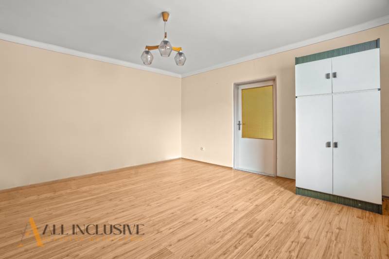 NA PREDAJ 3-IZBOVÝ RODINNÝ DOM, PUSTÉ ÚĽANY - Izba v rodinnom dome s podlahou s dreveným dekorom a bielou skriňou.