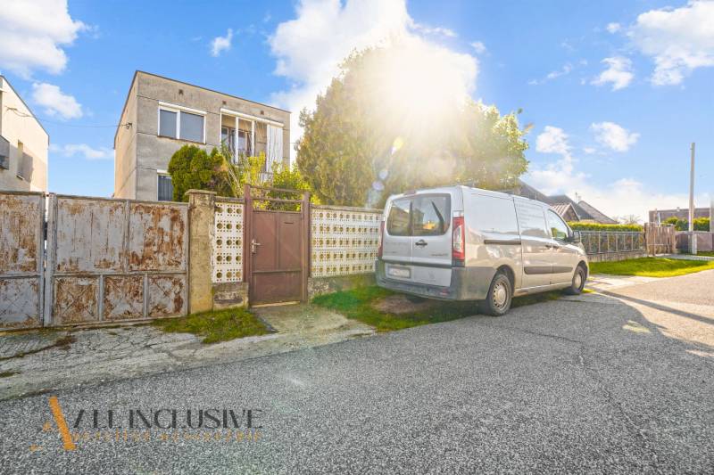 REZERVOVANÉ 4-IZBOVÝ POSCHODOVÝ RODINNÝ DOM, VEĽKÁ MAČ - Rodinný dom vo Veľkej Mači s autom na príjazdovej ceste a slnečným počasím.