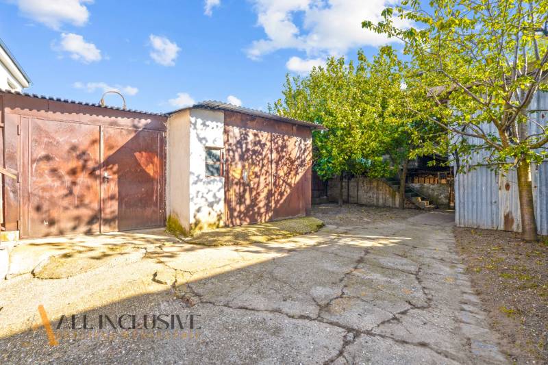 REZERVOVANÉ 4-IZBOVÝ POSCHODOVÝ RODINNÝ DOM, VEĽKÁ MAČ - Dvor pri rodinnom dome vo Veľkej Mači so stromami a hospodárskou budovou.